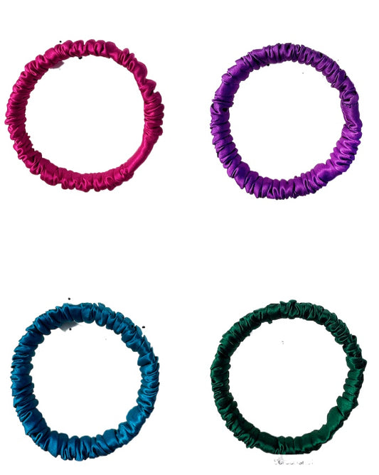 Four colorful hair ties in pink, purple, blue, green