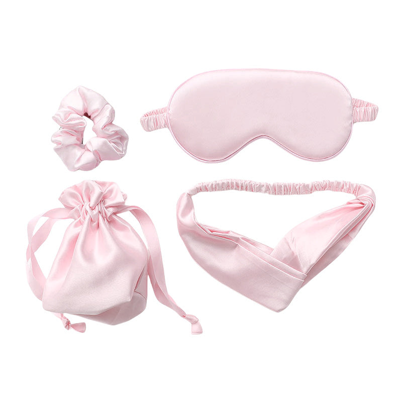 Pink satin sleep mask, hair scrunchie, headband, and drawstring bag
