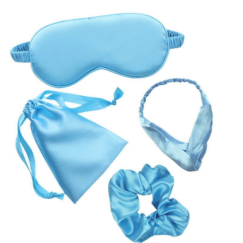 Set of blue satin sleep mask, headband, drawstring bag, and scrunchie