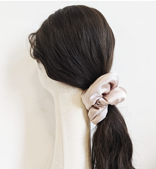 hair tied in a ponytail using a large pink scrunchie