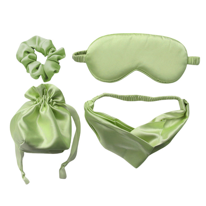 Set of green satin items including a sleep mask, headband, pouch, and scrunchie