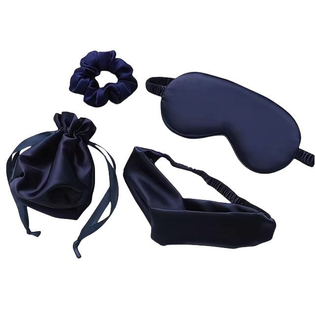 Set of navy blue satin items including a sleep mask, scrunchie, pouch