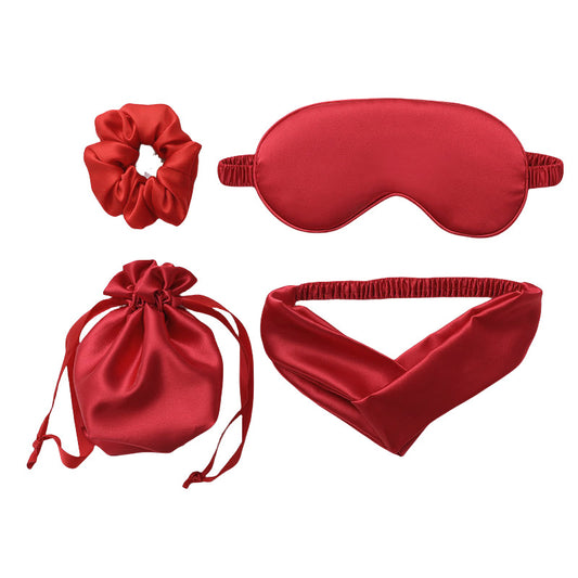 Set of red satin items including a scrunchie, sleep mask, drawstring bag, and headband